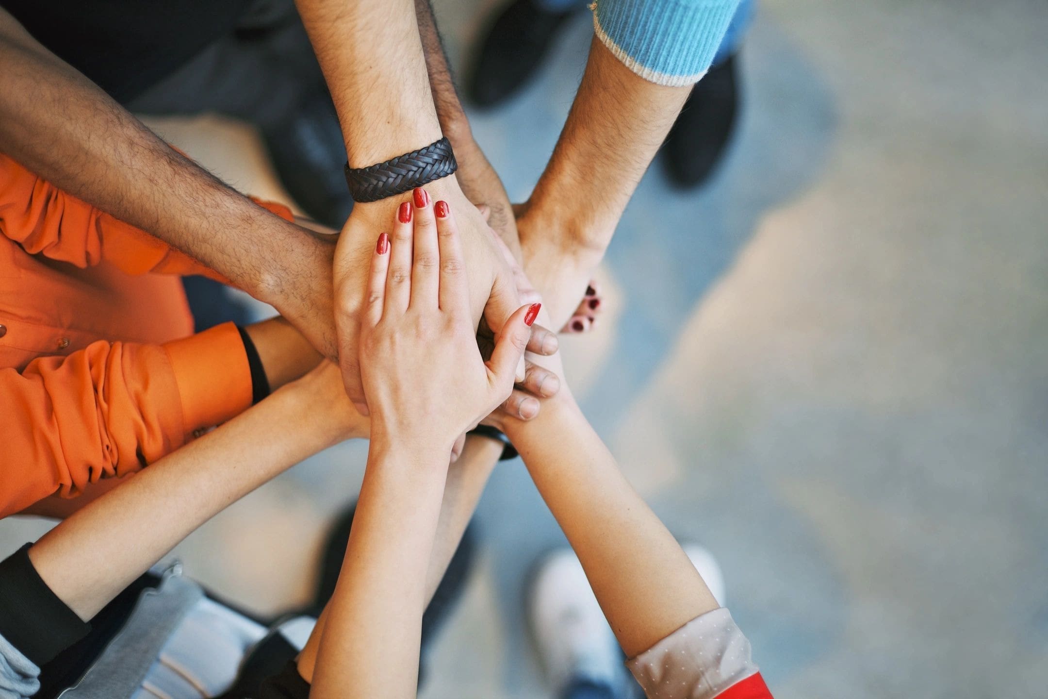 A group of people holding hands in the middle of a circle.