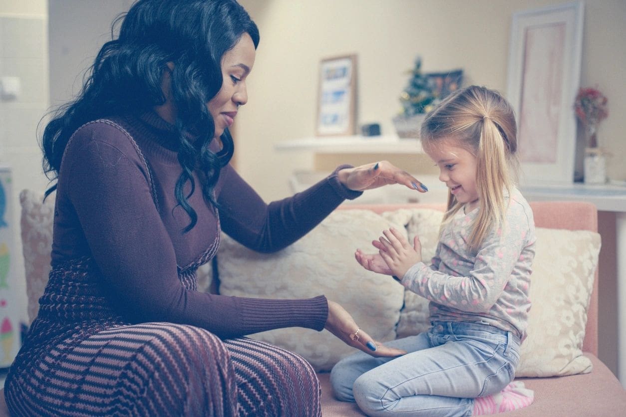 A woman and child sitting on the floor.