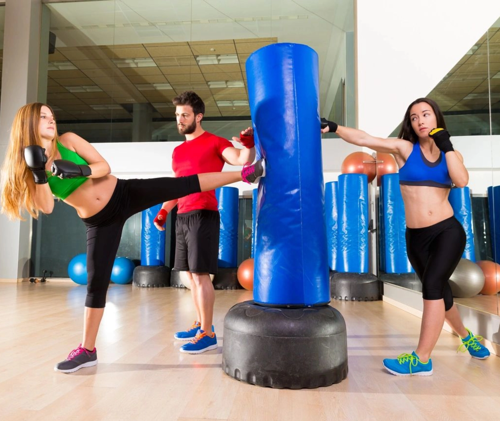 Three people are doing different exercises in a gym.