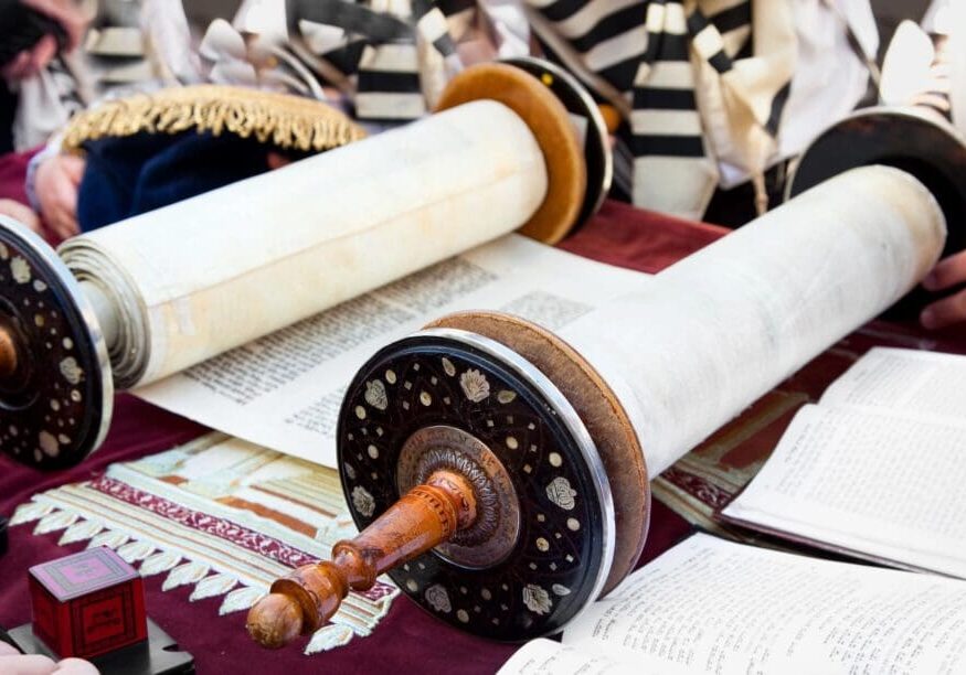 A torah scroll is sitting on top of the table.